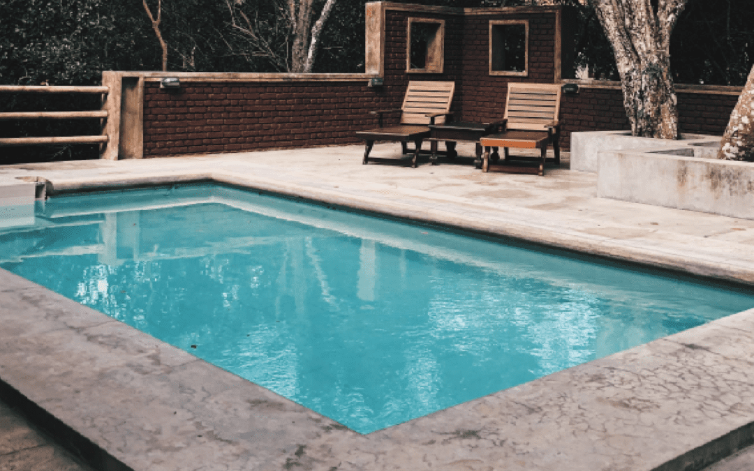rectangle pool with reclining chairs and stone surround